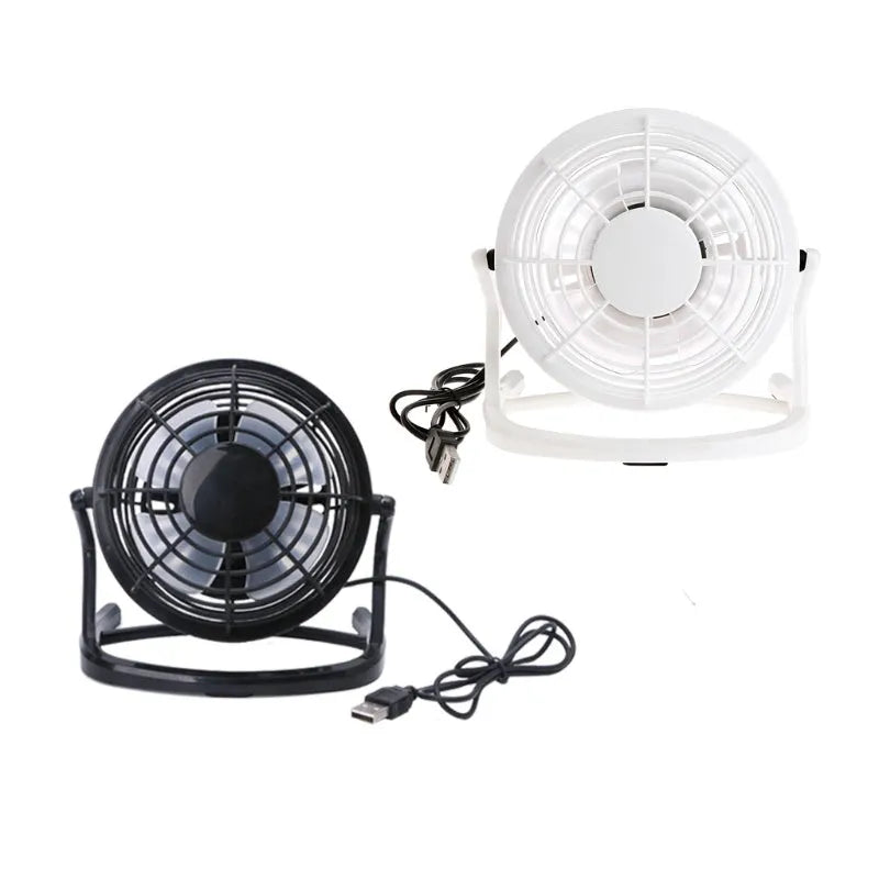 Mini black USB desk fan with adjustable tilt, shown on a desk next to a laptop.