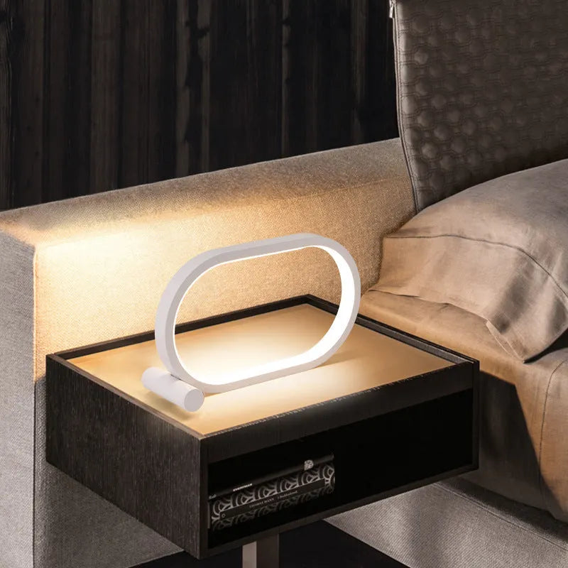USB plug-in oval acrylic touch lamp with dimmable LED, metal body, on a bedside table