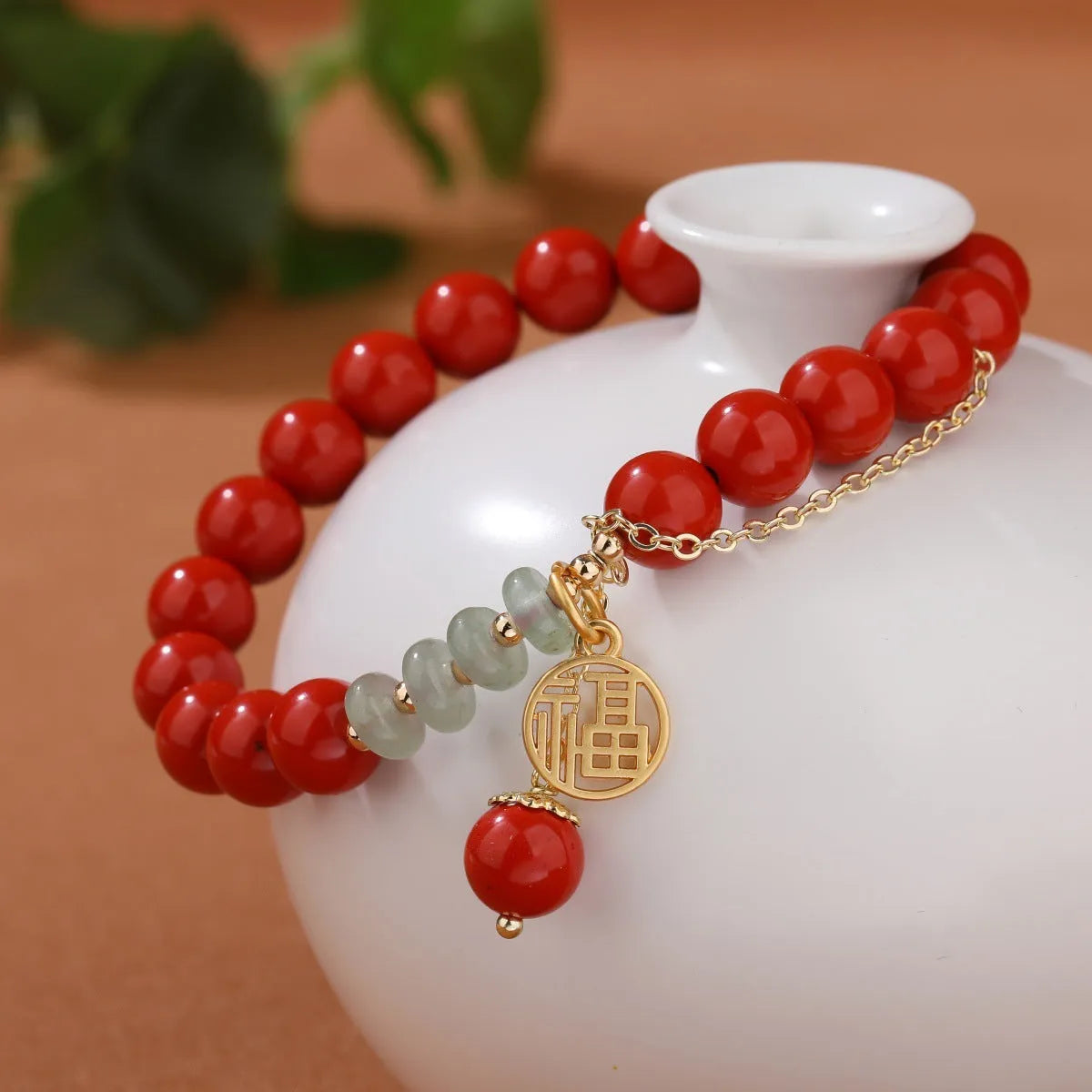 Retro women's bracelet with red sand cinnabar fu character pendant, jade spacer beads, and tassel detailing