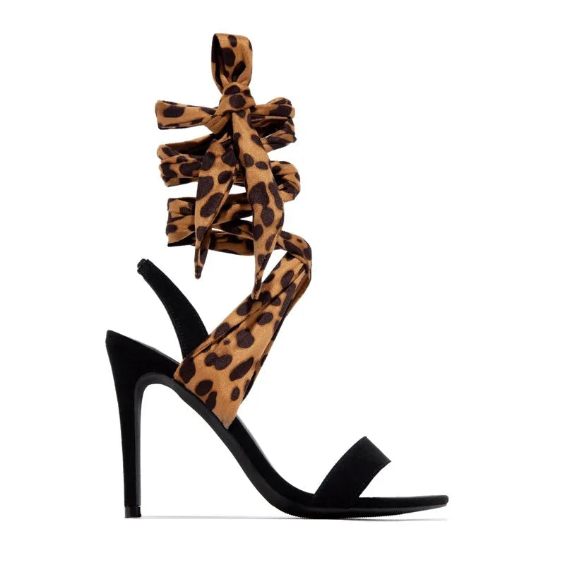 Light brown women's high-heeled sandals with leopard print and Roman cross straps on a fine high heel.