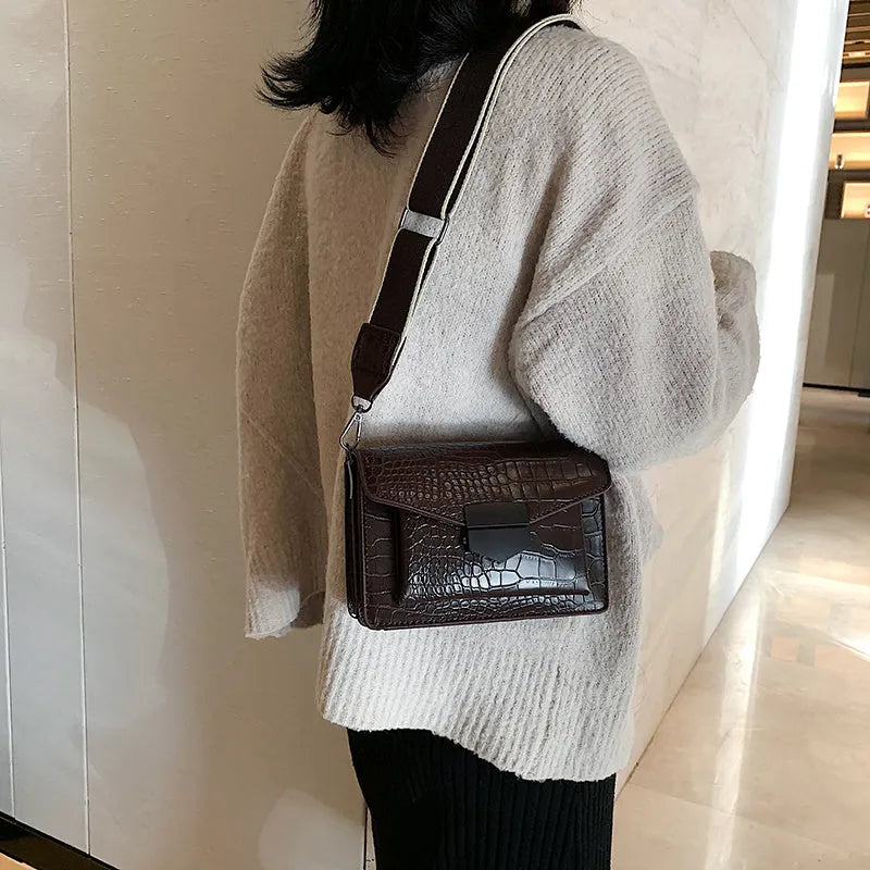 Vintage PU leather crossbody bag in black showing interior organisation for phones and wallets