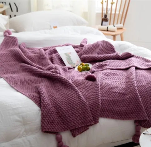 Nordic style knitted acrylic blanket with fringed edges on a sofa, showing its 130x170cm size and plain texture.