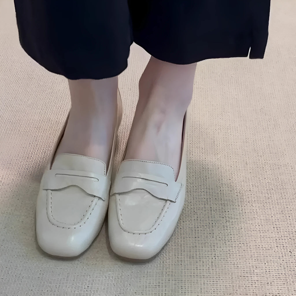 Beige white women's square toe flat shoes with cowhide upper and low heel on a plain background
