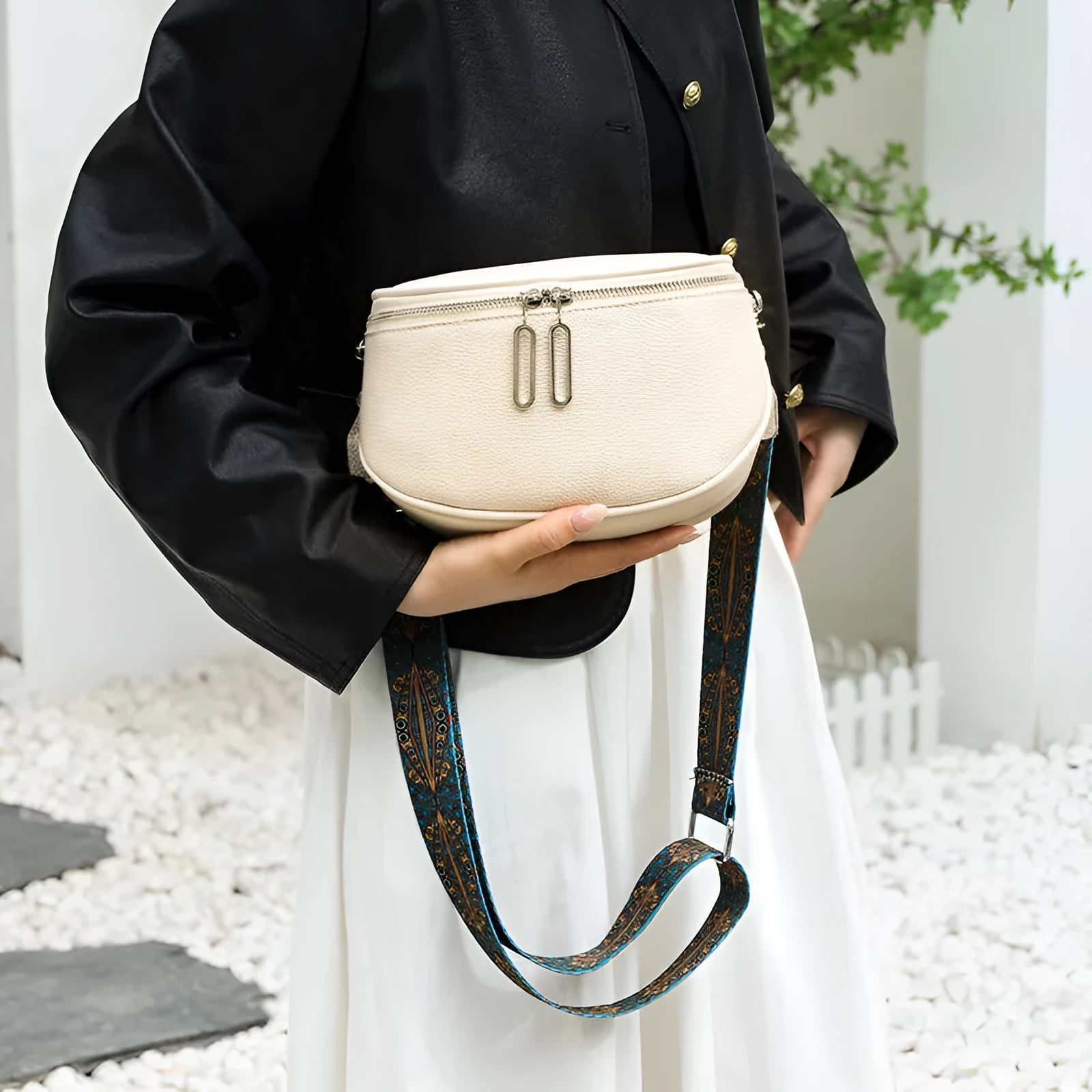 Women's saddle-shaped PU leather messenger bag in black colour with single shoulder strap and sewing line details