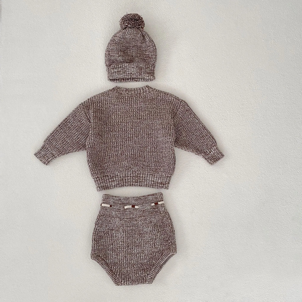 Dark brown knitted baby girl three-piece set with removable fur ball hat, blouse, and shorts