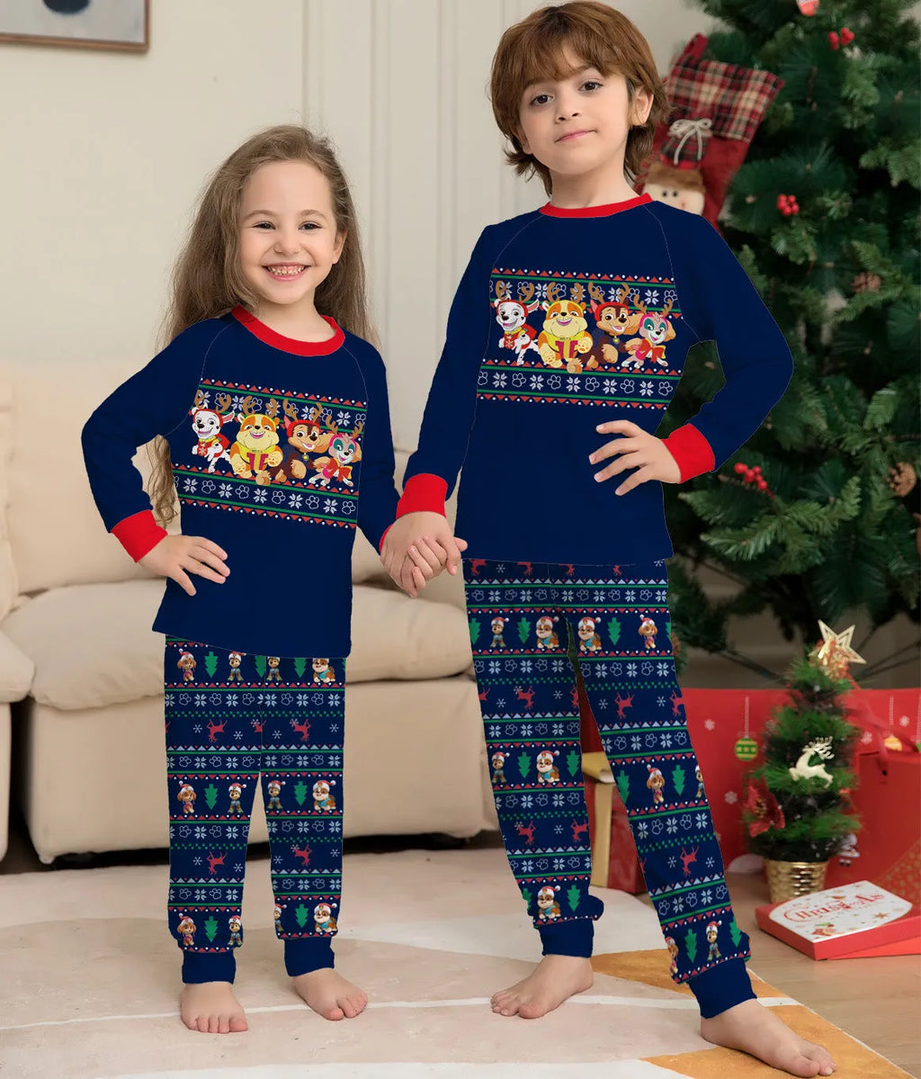 Family wearing matching red deer plaid Christmas pyjamas with adults, children, baby, and dog