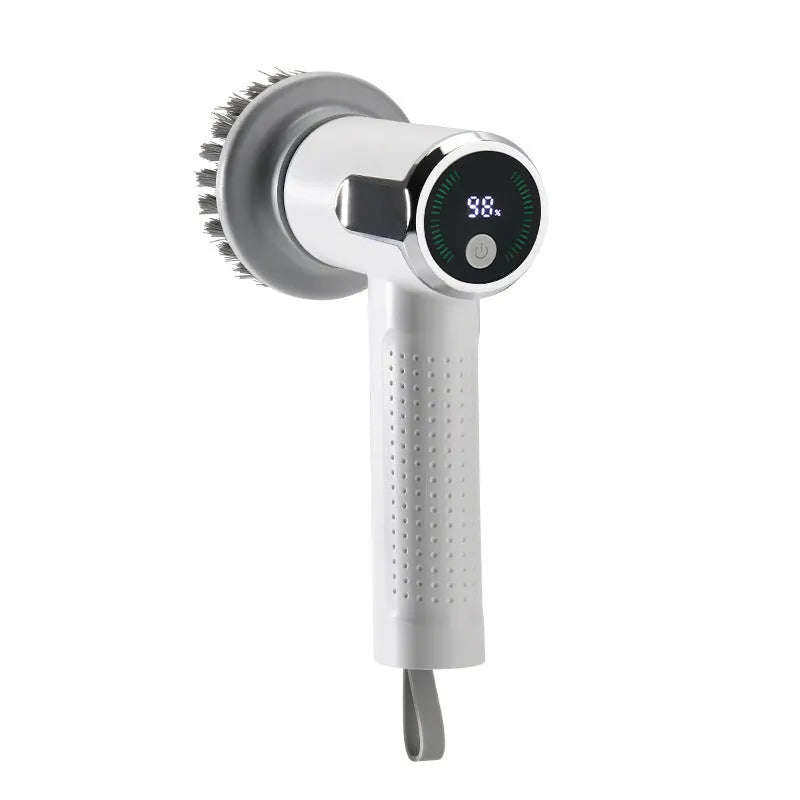 White cordless electric cleaning brush with interchangeable scrubber heads on a kitchen counter