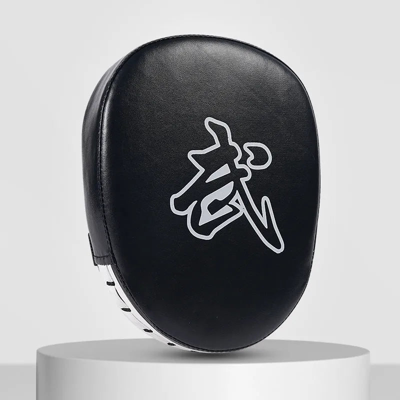 Red and black curved boxing punch mitts held in a trainer's hands for Muay Thai or Sanda practice.