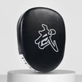 Red and black curved boxing punch mitts held in a trainer's hands for Muay Thai or Sanda practice.