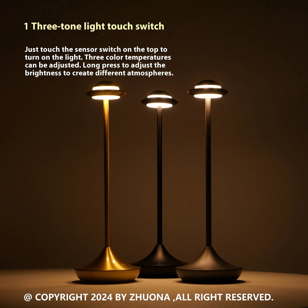 Rechargeable UFO-shaped metal desk lamp in black on a wooden table.