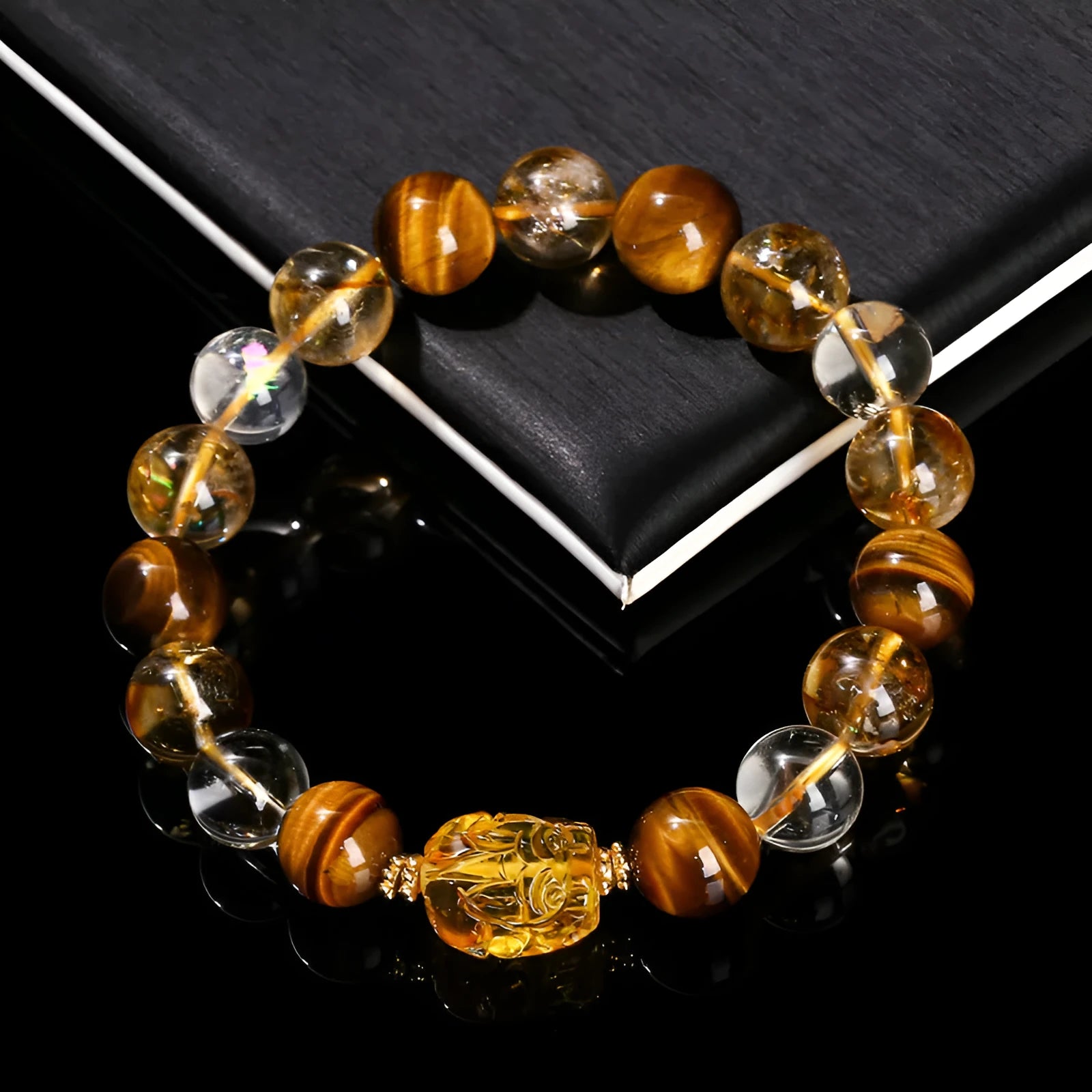 Natural yellow tiger's eye and citrine bracelet with 10mm round beads and a silver pi xiu charm on a wrist.