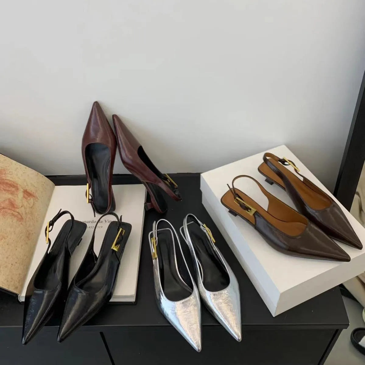 Thin low heel strap pointed leather shoes in black, red, brown, or silver on a rubber sole.