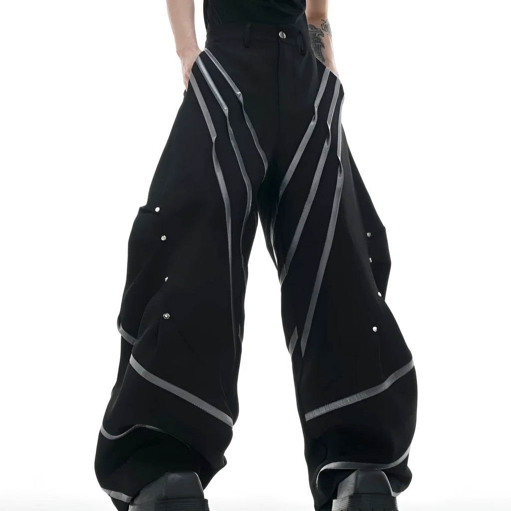 Men's black polyester trousers with metal striped rivet details and pleated front.