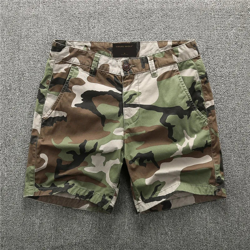 Green camouflage cotton shorts with zip fly on a mannequin, showing mid-waist fit and shorts length for casual wear.