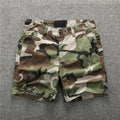 Green camouflage cotton shorts with zip fly on a mannequin, showing mid-waist fit and shorts length for casual wear.