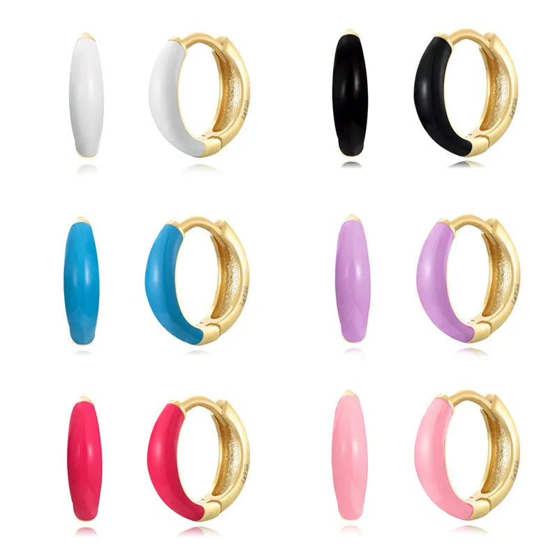 A pair of curved oval epoxy earrings on a U-shaped silver-plated copper base.