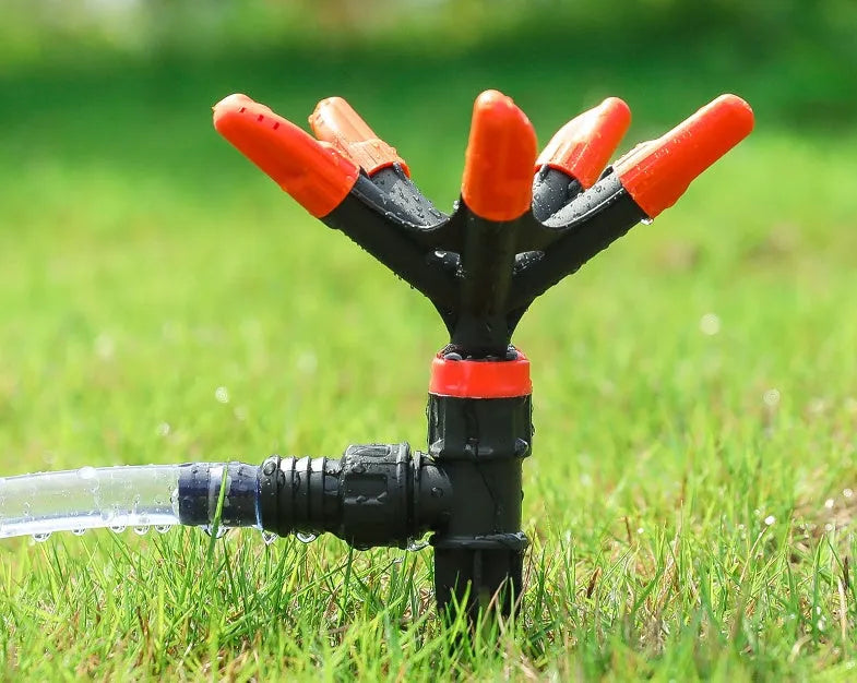 Orange plastic garden insert sprinkler with rotating water spray nozzle, 14x26.5cm