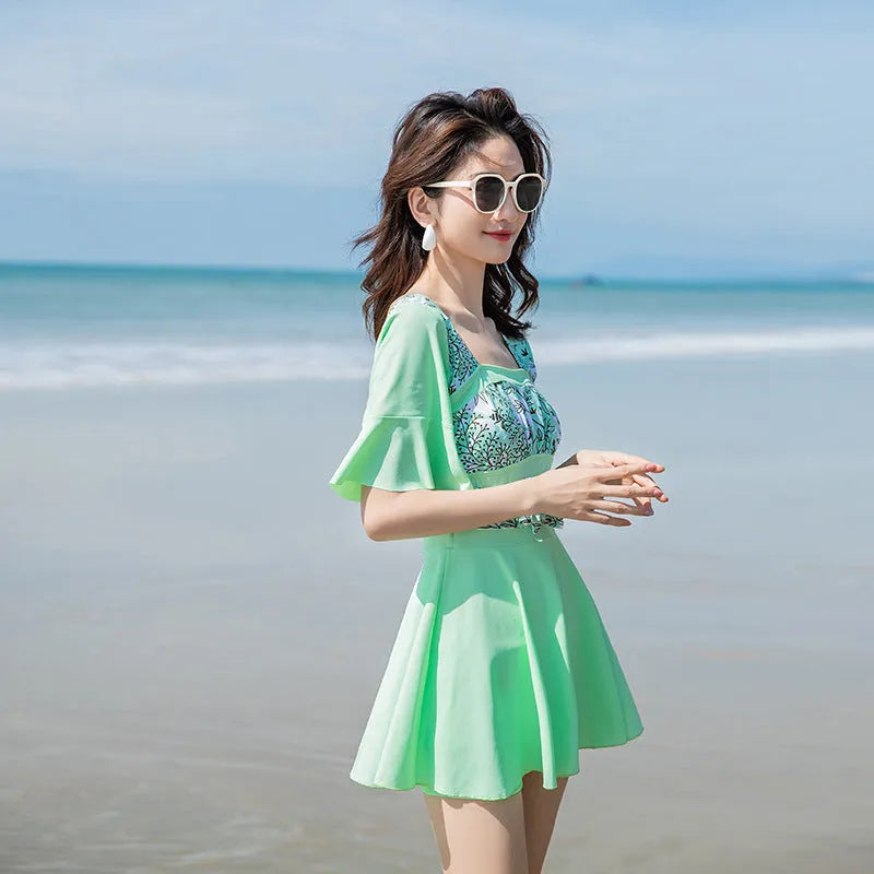 Green and blue printed one-piece swimsuit for women, shown in sizes M L XL 2XL.