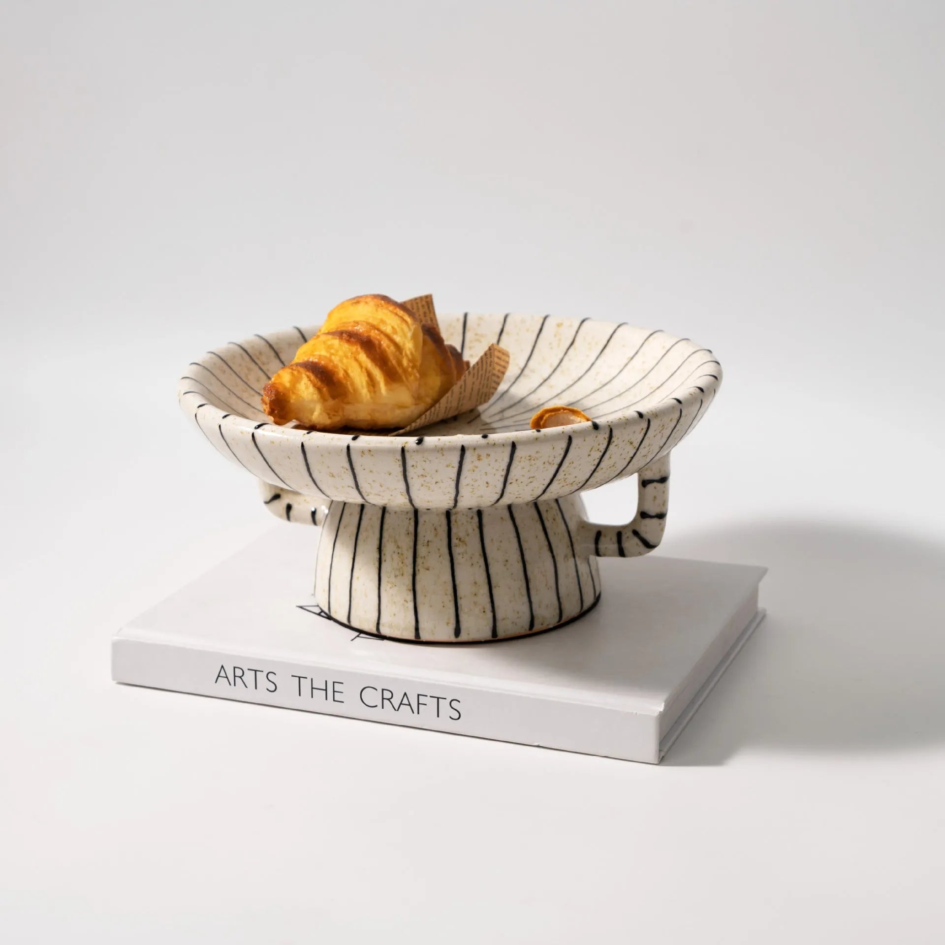 Black and white striped synthetic resin fruit plate on a wooden surface.