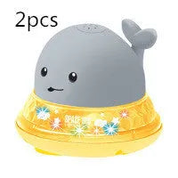 Whale-shaped electric bath toy spraying water with flashing lights, floating in baby bathtub