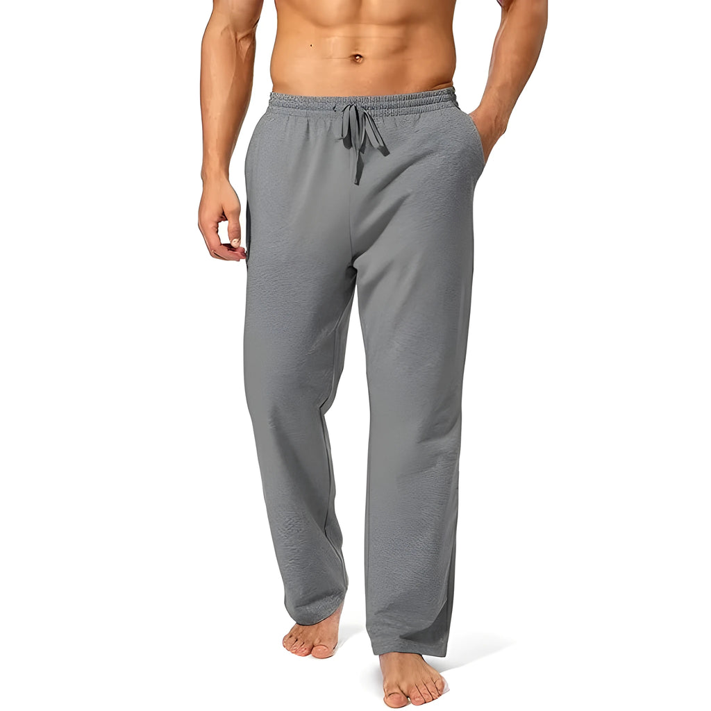 Men's loose fit casual trousers in black polyester fabric on a hanger.