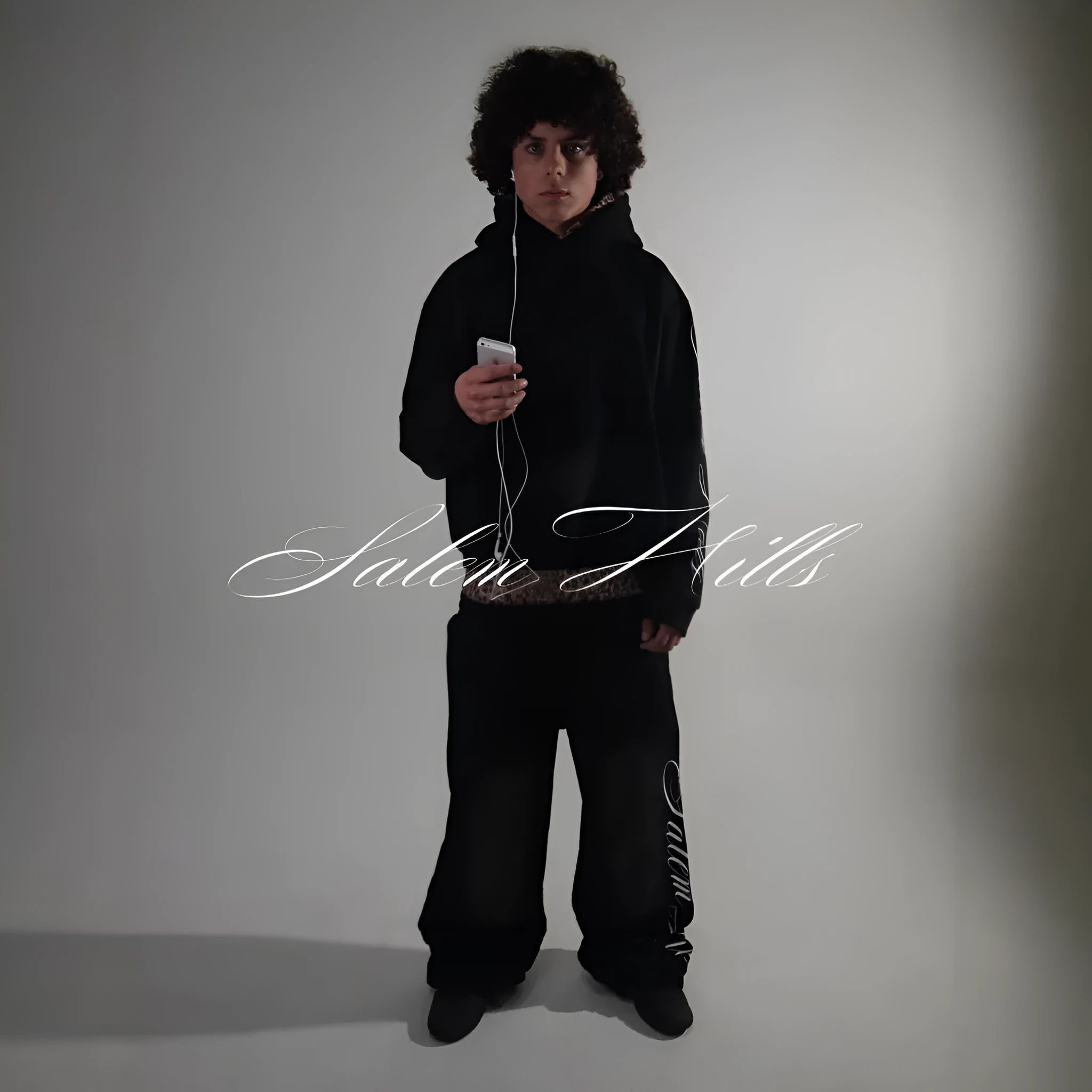 Men's black punk print pullover hoodie and matching trousers fleece-lined suit set laid flat.