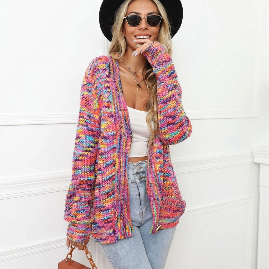 Rose red loose fit knitted cardigan coat with rainbow coloured stripes, shown on a model.