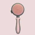 Green and pink 2-in-1 silicone cat hair brush with retractable slicker brush and massaging head.