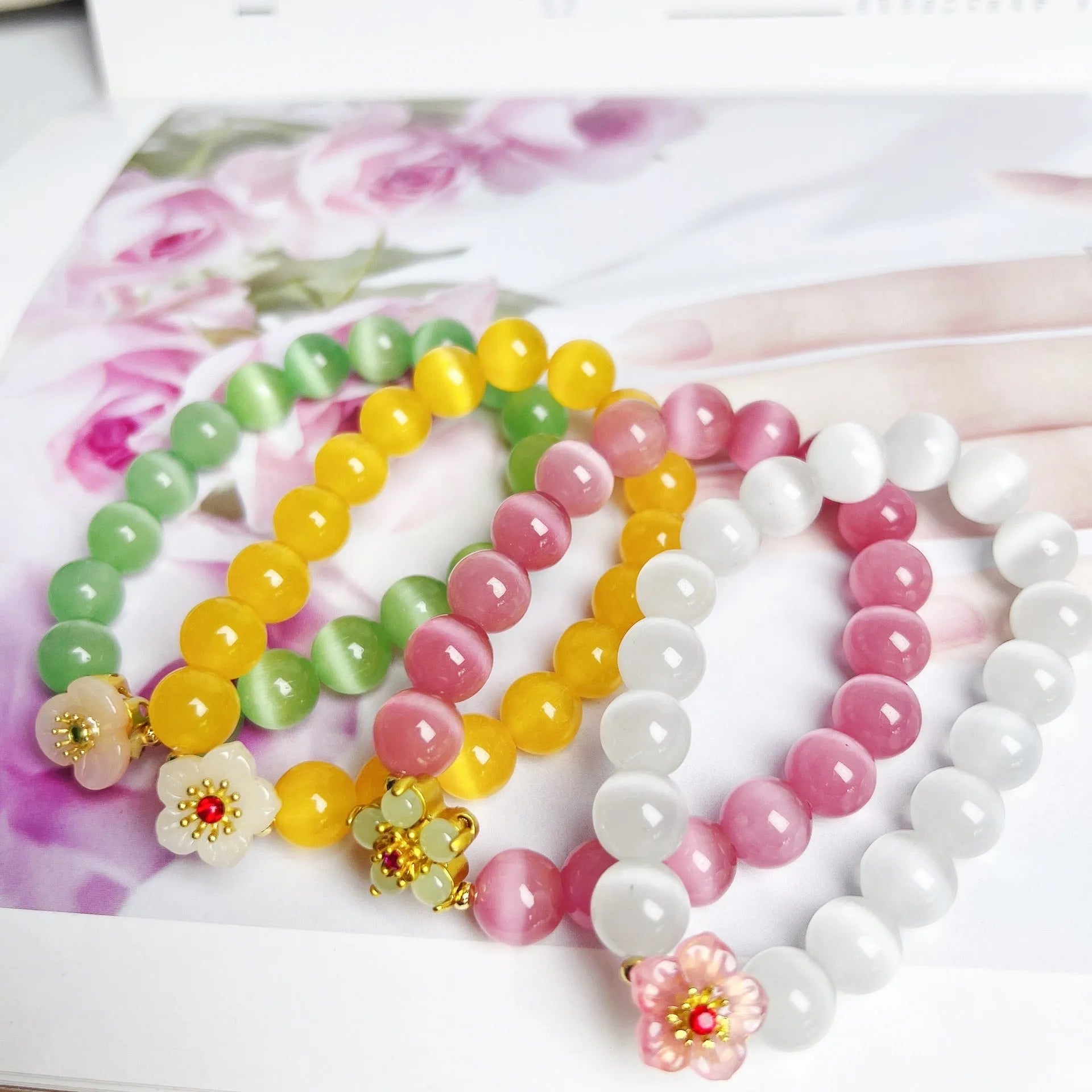Handmade glass bead bracelet with floral design in yellow, pink, white, or green.