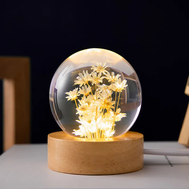 Luminous 3D dandelion crystal ball LED desk light on a beech wood stand.
