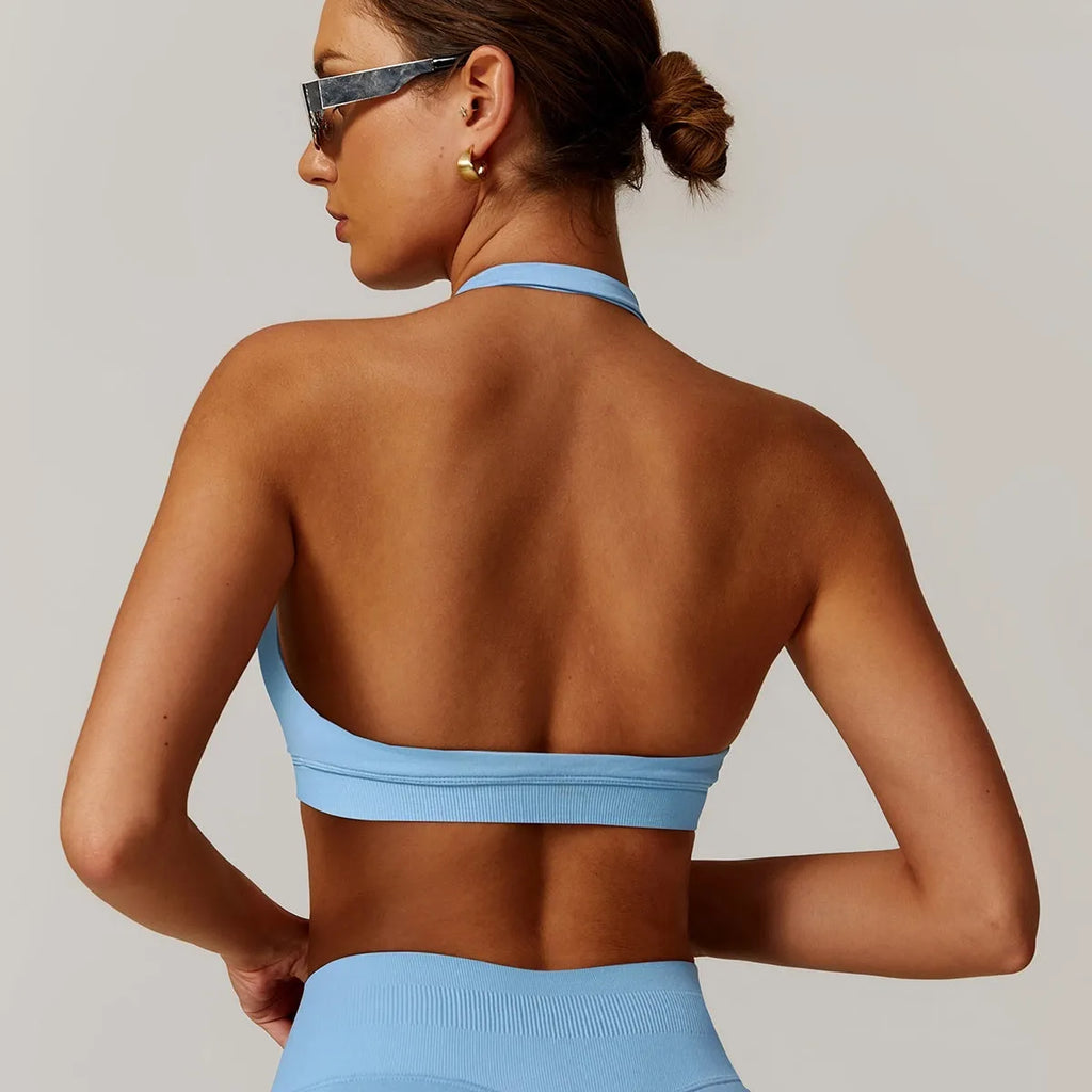 Women's black halter neck sports bra with removable pads on a mannequin.