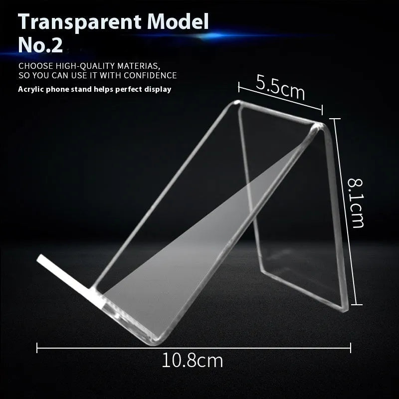 Clear acrylic mobile phone stand on a desk with a smartphone placed in it, showing the universal fit and transparent design.