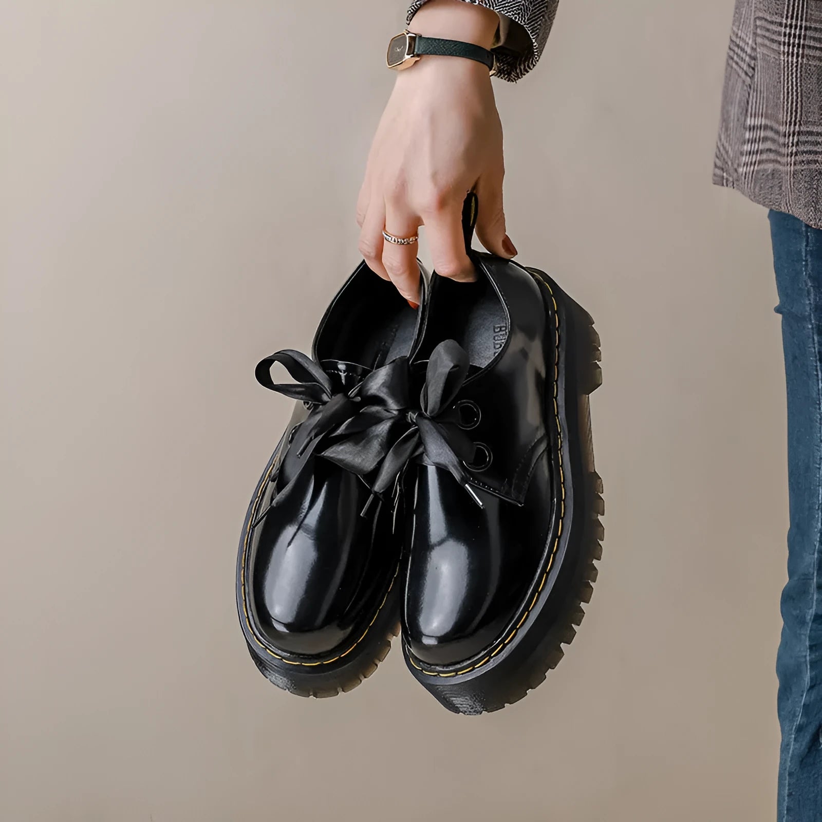 Black and white women's lace-up shoes with a thick sole, cross straps, and ribbon details.