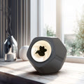Floating magnetic fluid Bluetooth speaker in silver gray on a desktop, with magnetic fluid swirling inside the chamber