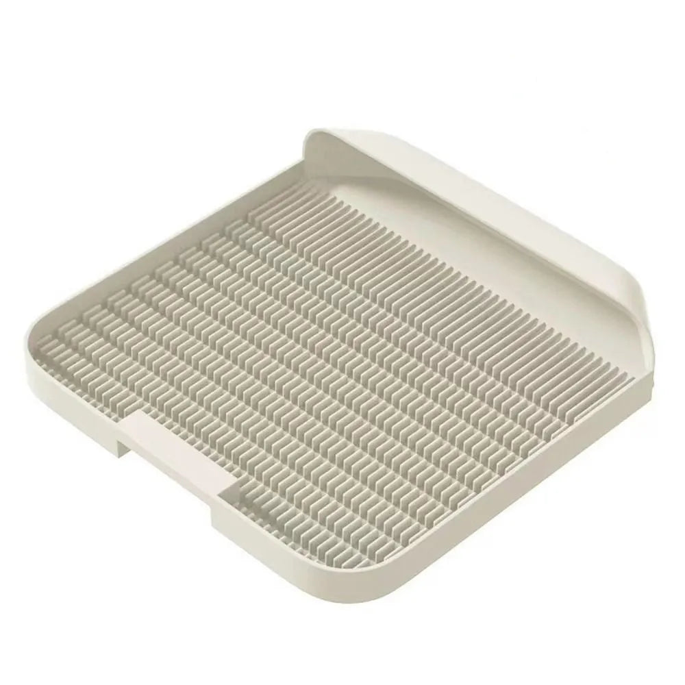 Large black cat litter pedal with slanted mouth and textured non-slip mat next to litter tray