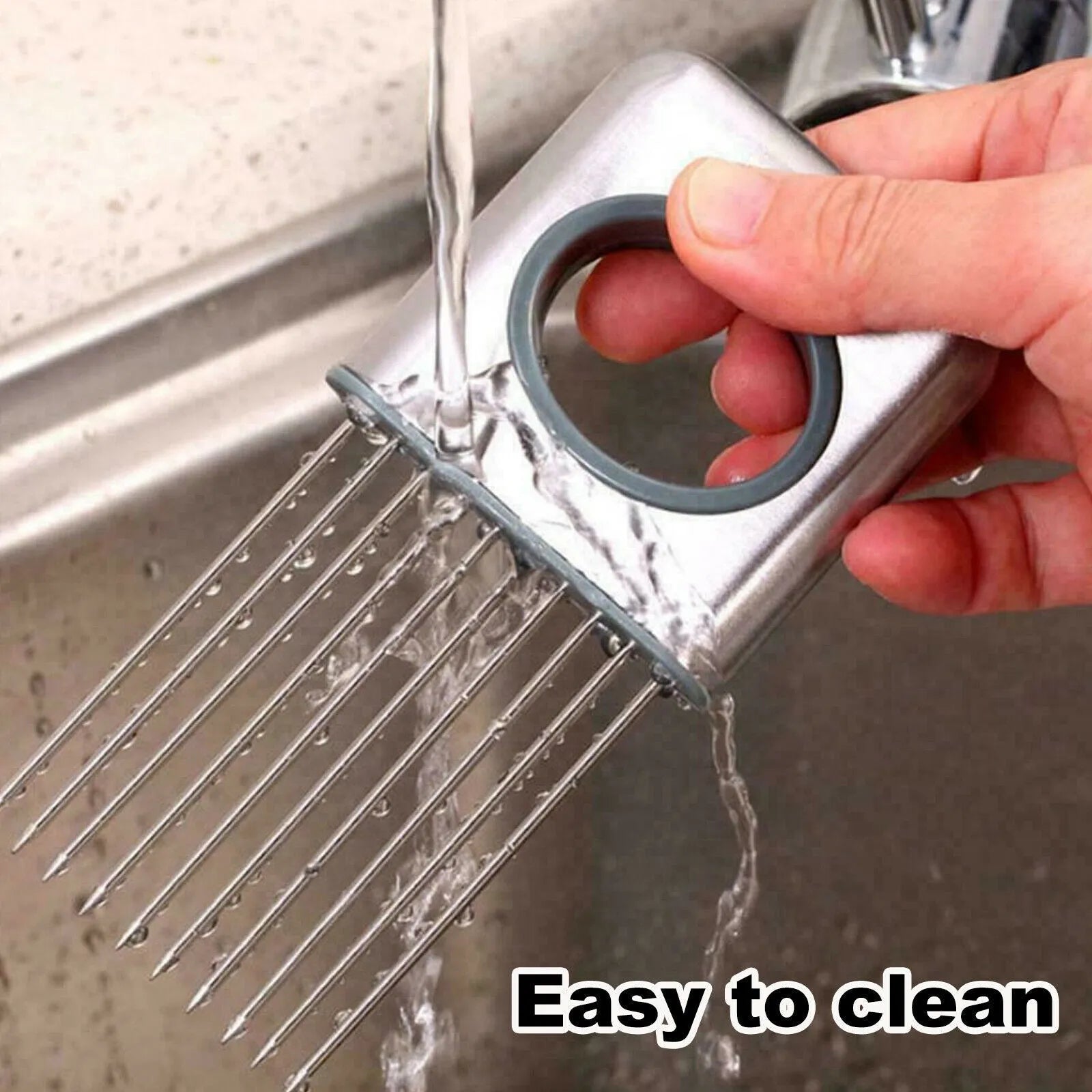 Stainless steel onion holder with sharp prongs and a red finger guard on a kitchen counter.