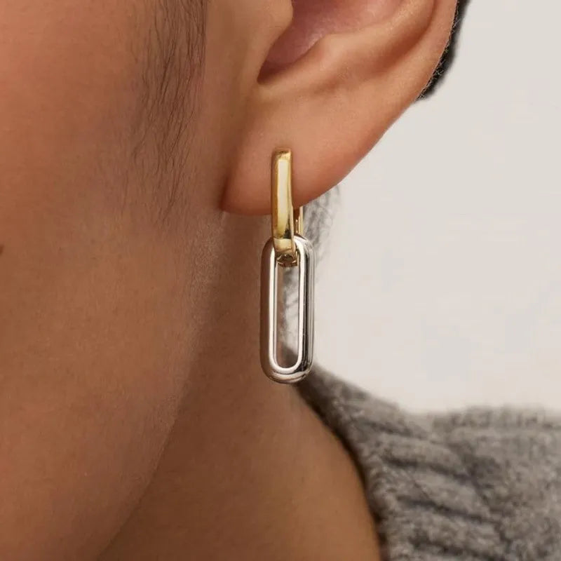 14K gold and silver two-tone geometric U-shaped earrings on a light background showing the copper core and metallic finish