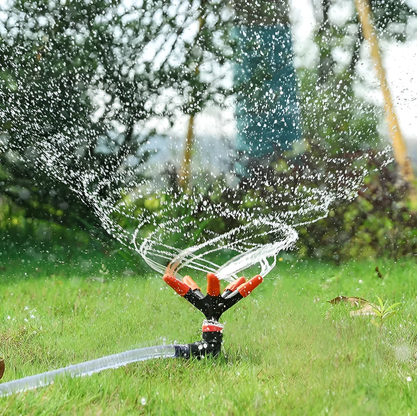 Orange plastic garden insert sprinkler with rotating water spray nozzle, 14x26.5cm