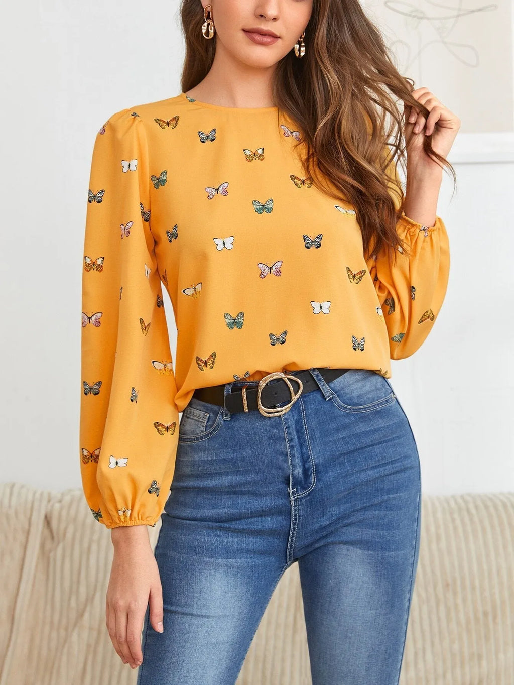 Women's green loose-fit long sleeve shirt with a colourful butterfly print.