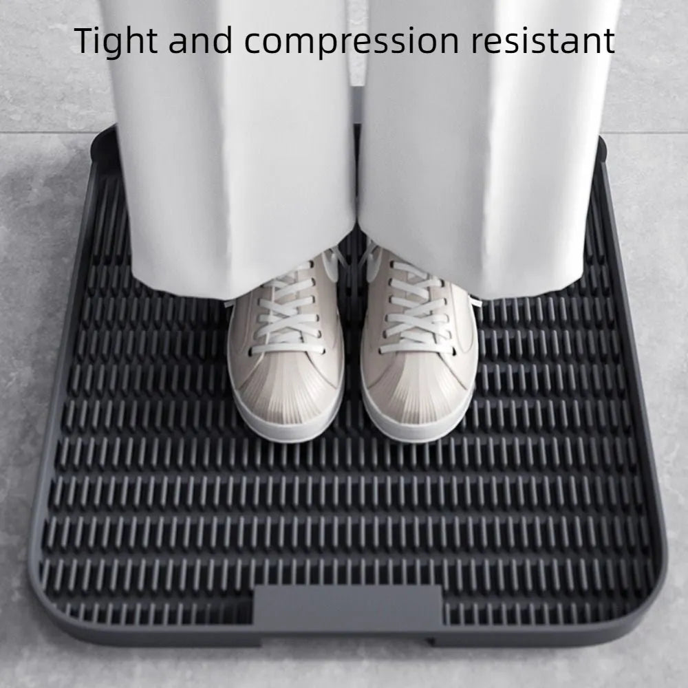 Large black cat litter pedal with slanted mouth and textured non-slip mat next to litter tray