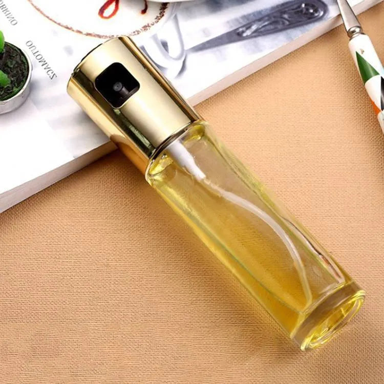 Gold ABS and glass oil and vinegar spray bottle with push-type pump, 17.5cm tall.