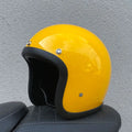A retro-styled half motorcycle helmet made from glass fibre, shown in a matte black flower colour finish.