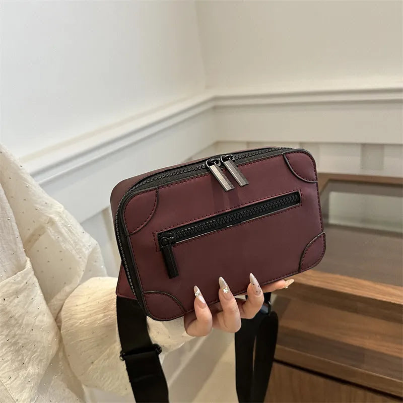 Small square women's crossbody bag in PU leather, shown in street-trend style with a single strap.