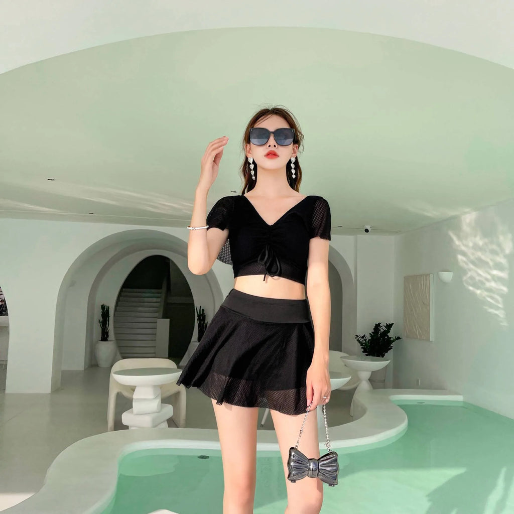Women's solid colour two-piece swimsuit set with a skirt, shown in white, black, or pink.