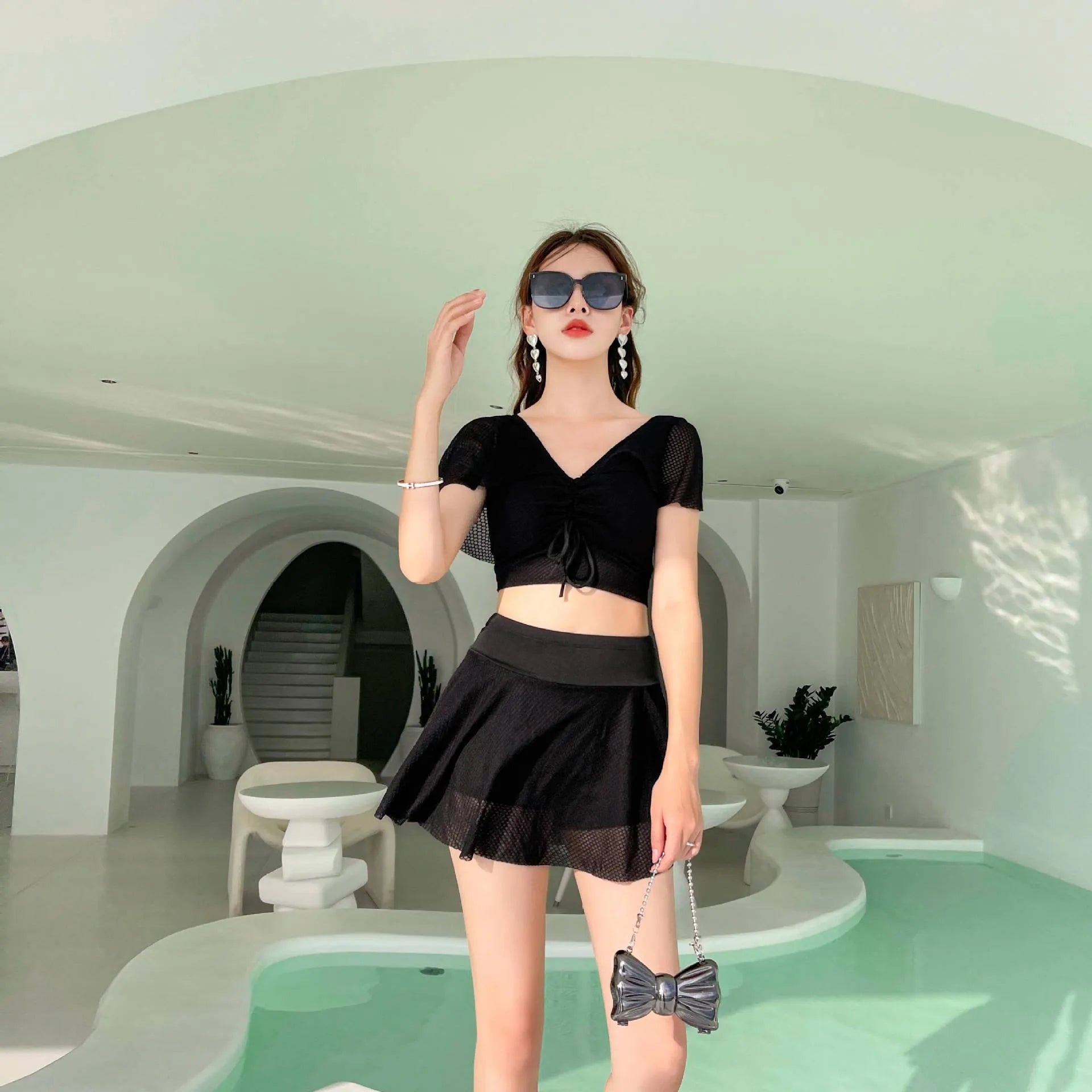 Women's solid colour two-piece swimsuit set with a skirt, shown in white, black, or pink.