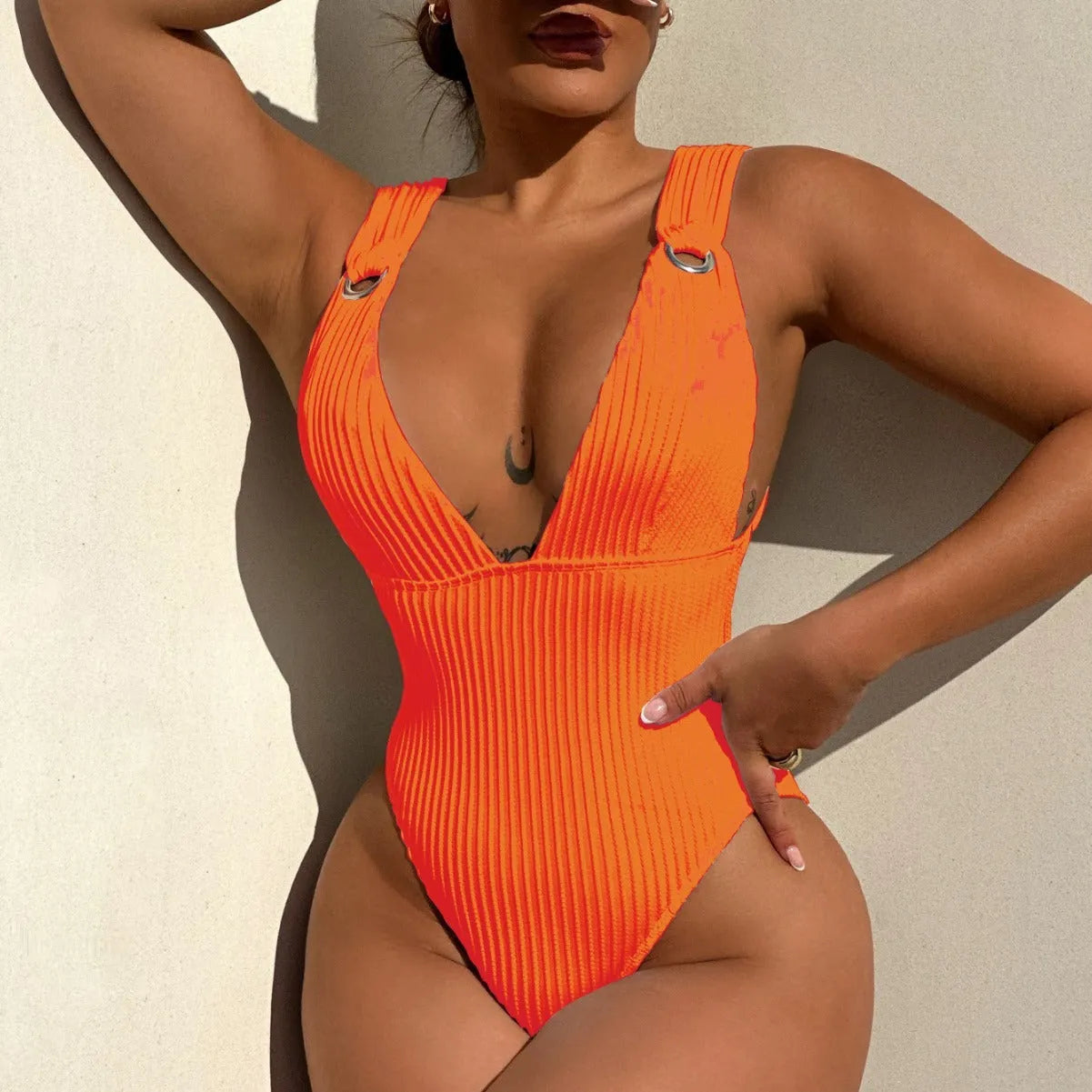 Solid colour one-piece swimsuit for women in black, white, green, or orange.
