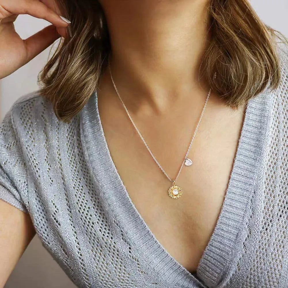 Geometric sunflower daisy pendant necklace on a silver cross chain, adjustable length.