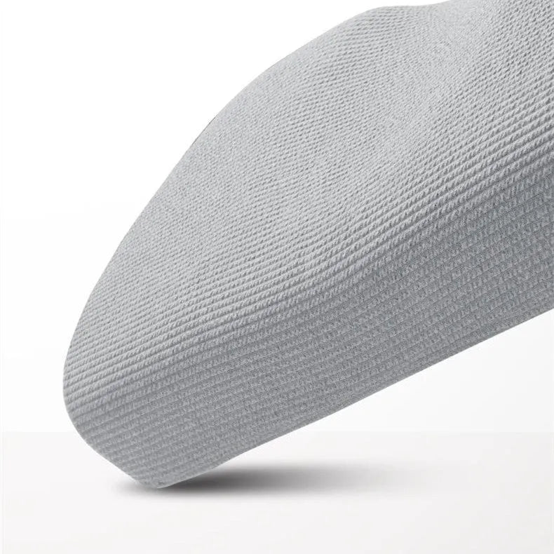 Grey memory foam massage pillow with knitted cotton cover on a bed, offering adjustable neck support for sleep