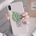 White silicone iPhone case with a painted green plant pattern on the back.