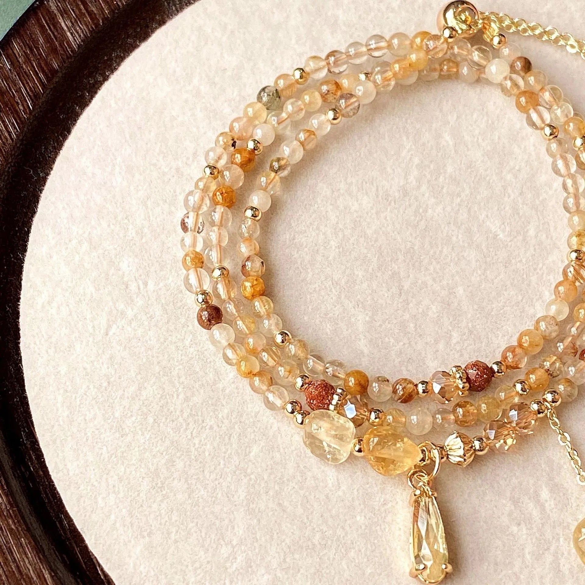 Women's three-circle citrine bracelet with caramel crystals and gold electroplated finish showing Saturn design detail
